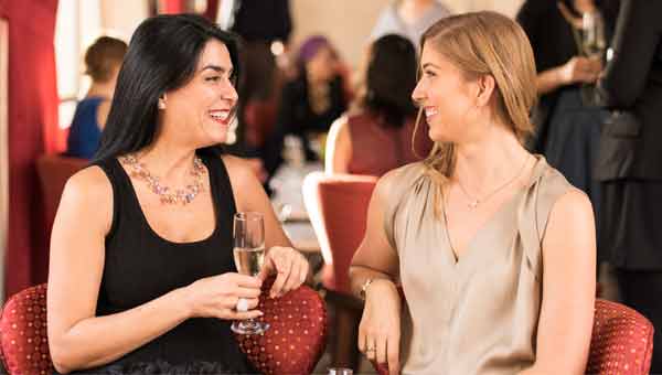 two women conversing over drinks.