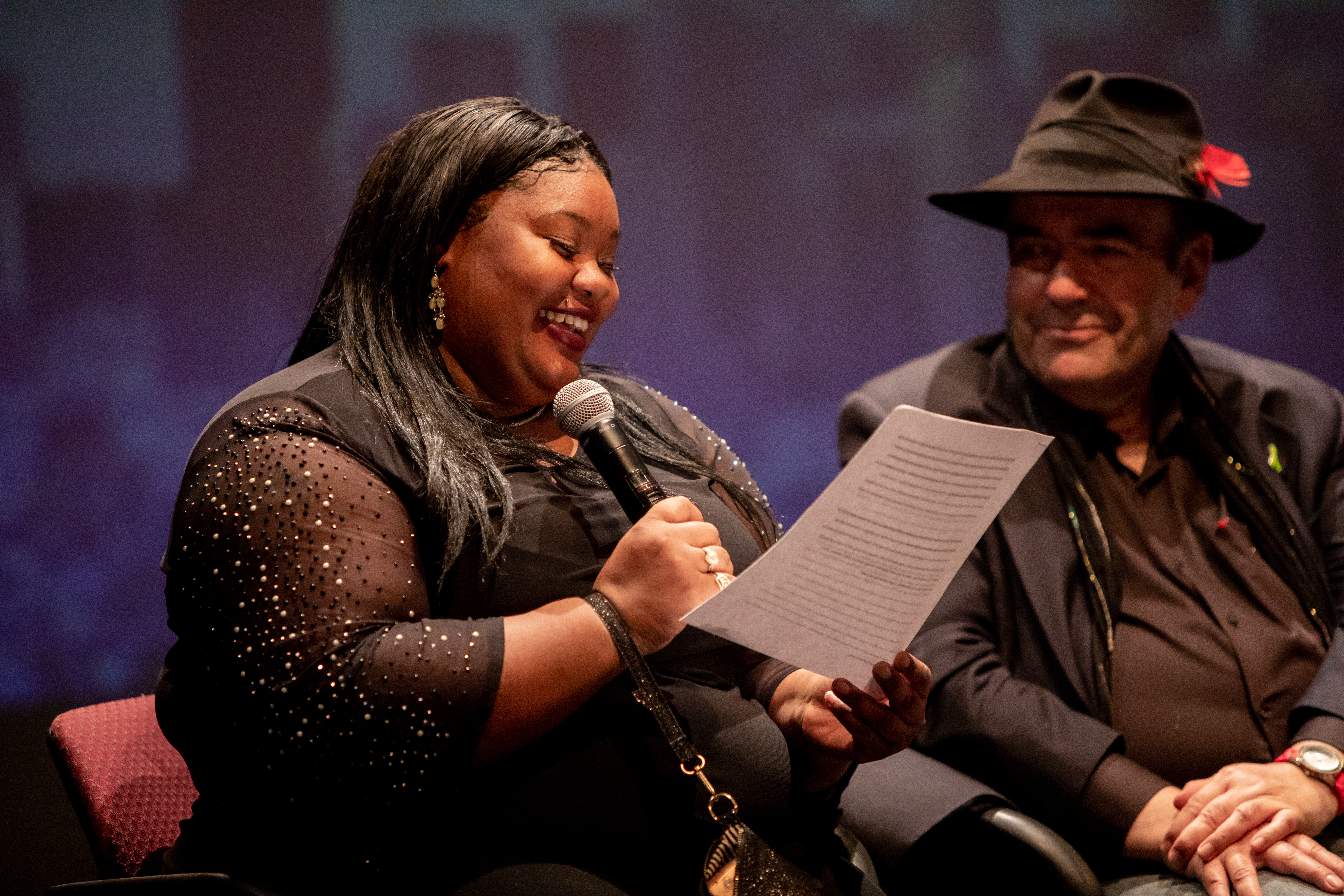 Woman with microphone reading from paper