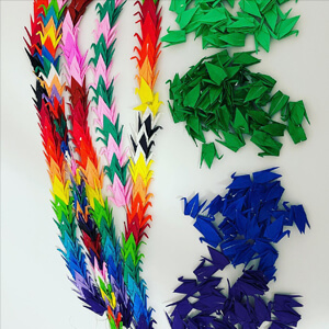 multi colored origami cranes stringed together.