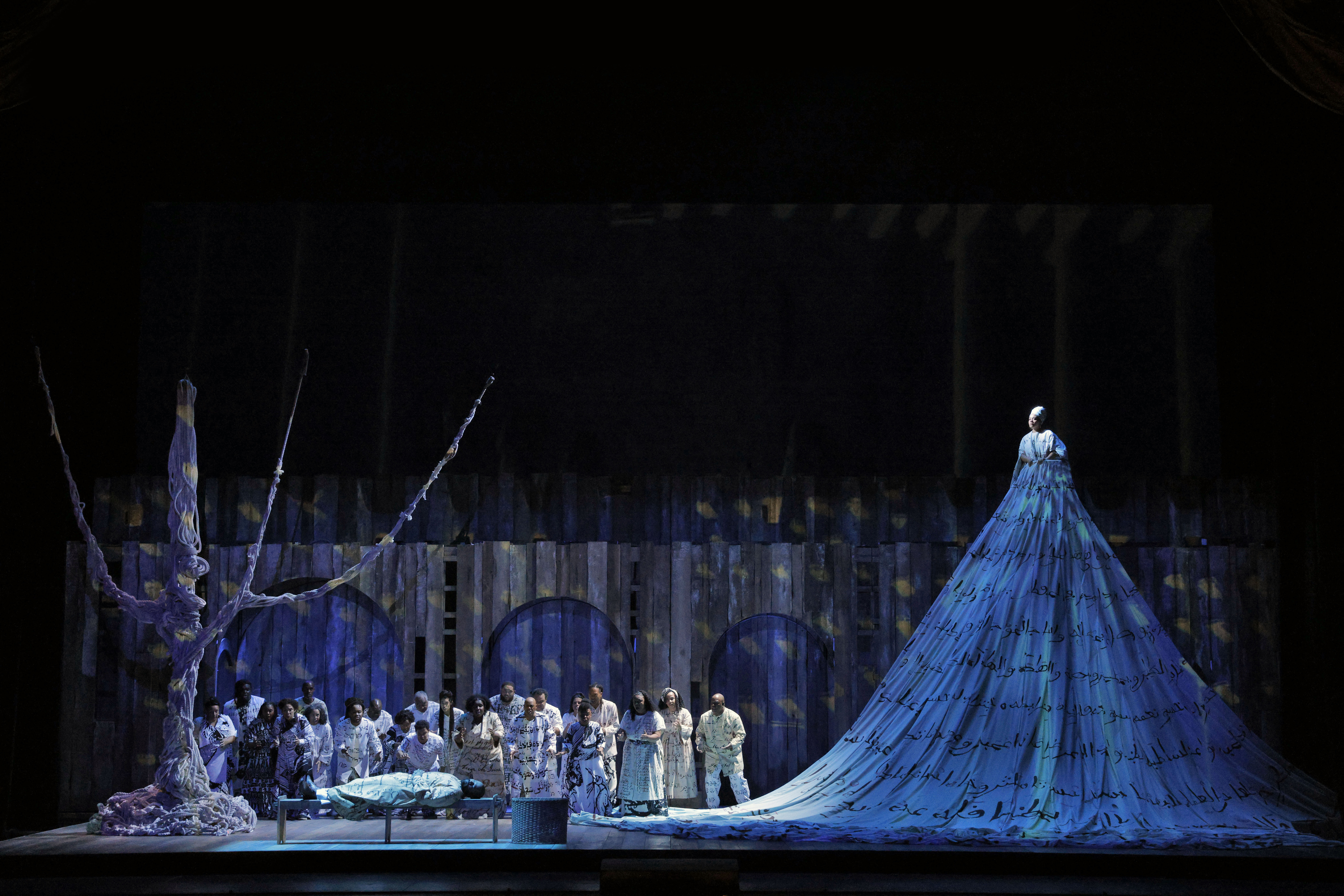 woman in a long blue dress elevated on stage
